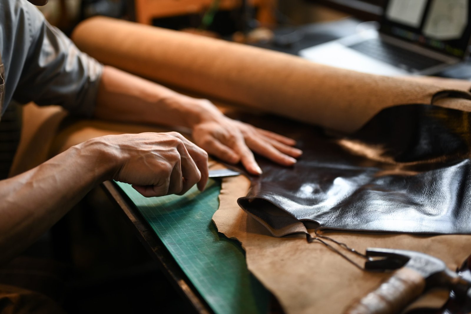 Craftsman cutting leather for gloves